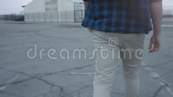 一个穿着格子衬衫和牛仔裤走路的人以史诗般的方式行走行走自信慢动作视频的预览图
