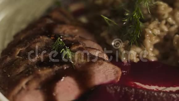 鸭肉片用棕色酱汁和甜菜慕斯调味与米饭一起食用视频的预览图