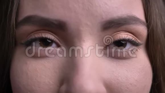 一张年轻美丽的白种人女性脸的特写镜头她的眼睛直视着相机带着微笑的表情视频的预览图