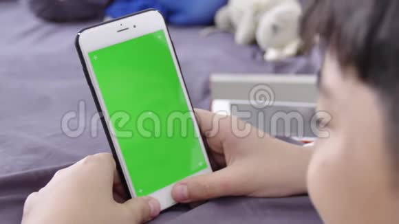 多莉拍摄的孩子手里拿着一部手机手里拿着一个绿色屏幕的Chroma键模型视频的预览图