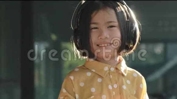 戴着耳机跳舞的亚洲孩子幸福的脸视频的预览图