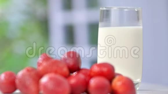 一堆鲜香的大草莓放在桌子上背景是一杯牛奶全盛视频的预览图