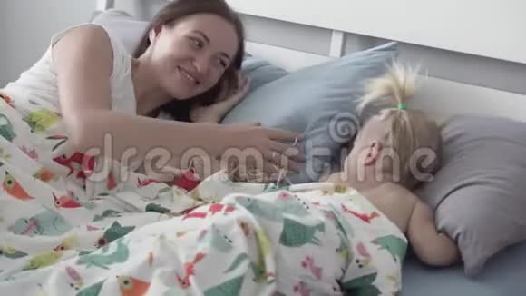妈妈让她的小女儿睡午觉视频的预览图