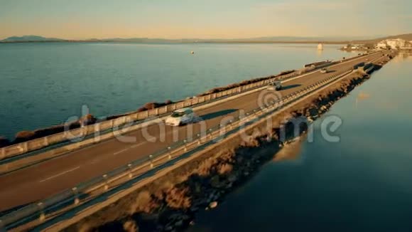 日落时不知名汽车沿海坝行驶的低空鸟瞰图意大利奥贝泰洛视频的预览图