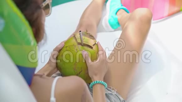 泳池里的美女喝着椰子果视频的预览图