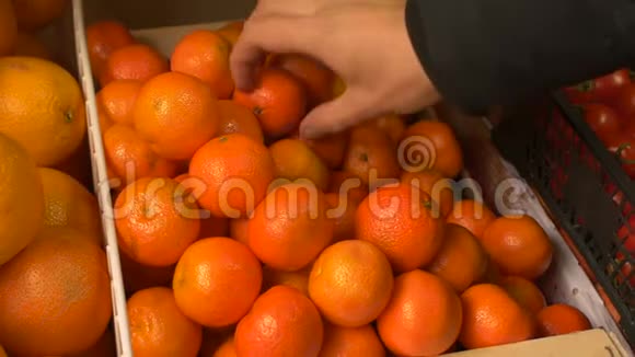男人在商店或商店接触感受和选择新鲜的普通话橘子视频的预览图