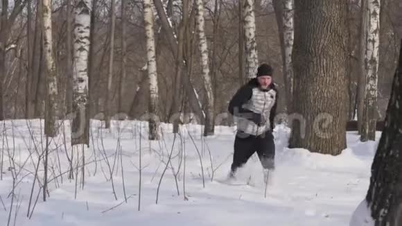 在冬天的森林里年轻人在雪地上奔跑冬季训练室外训练视频的预览图
