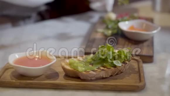 夹着草的三明治正在餐厅附近烹饪厨师用手在木板上做美味的食物视频的预览图