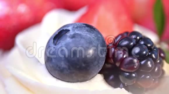 成熟的真正的黑色和红色浆果组成的白色蓬松的鲜奶油极端特写视频的预览图