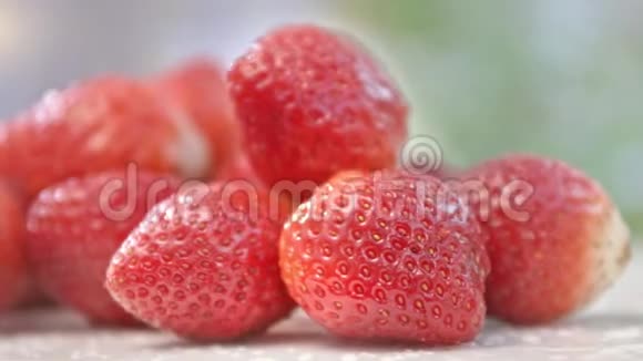 白色表面上的鲜红色草莓被晒黑的阳光包围视频的预览图