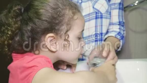 女孩吃完后仔细刷牙妈妈教她女儿吃饭后如何清洁和漱口视频的预览图