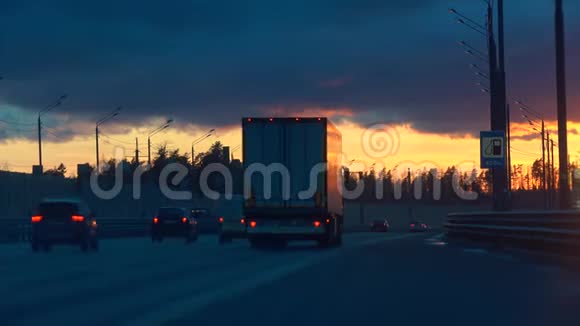 日落时的公路交通和加油站路标视频的预览图