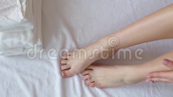 女性双腿用按摩疗法水疗中心铺白色毛巾视频的预览图