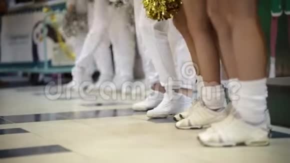 体育比赛啦啦队的女人站在室内挥舞着波姆球白色袜子和运动鞋视频的预览图