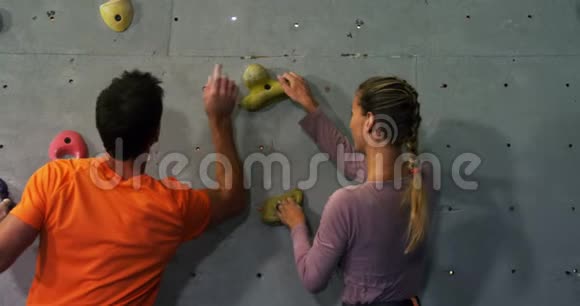 教练训练一个女人爬人造墙视频的预览图