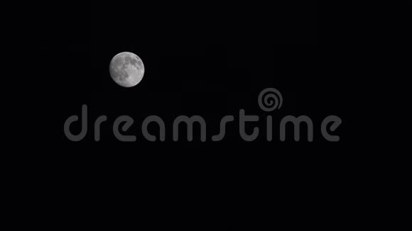 满月在夜空中的云彩中升起夜晚的背景视频的预览图