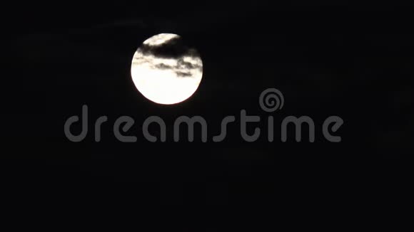 满月在夜空中的云彩中升起夜晚的背景视频的预览图