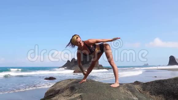 女子在靠近水面的海面上背着海浪做体操瑜伽练习健康的生活方式女人在做什么视频的预览图