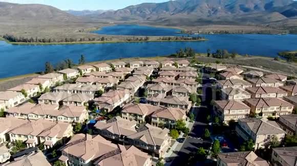 背景上与大湖大山相同的住宅公寓的鸟瞰图视频的预览图