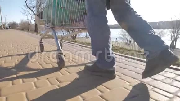 无家可归的人用手推车走路的后视图视频的预览图
