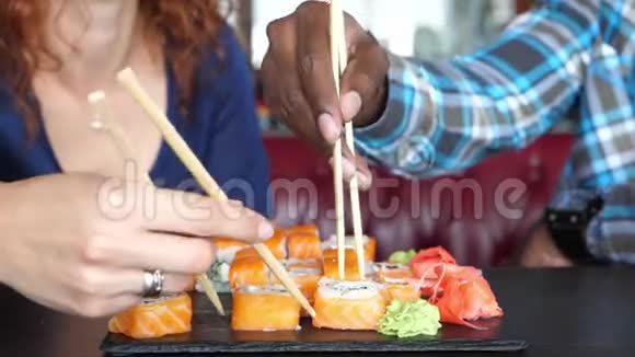 咖啡馆里的男人和女人吃寿司和交流视频的预览图
