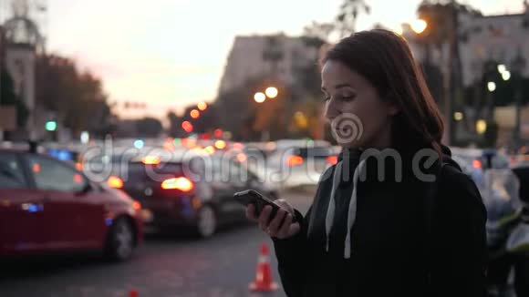 年轻美丽的微笑女子在手机城市街道汽车出租车音频信息语音识别等方面交谈视频的预览图