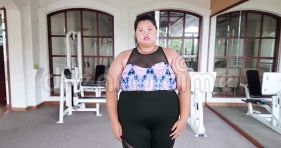 超重的女人站在健身房转身视频的预览图