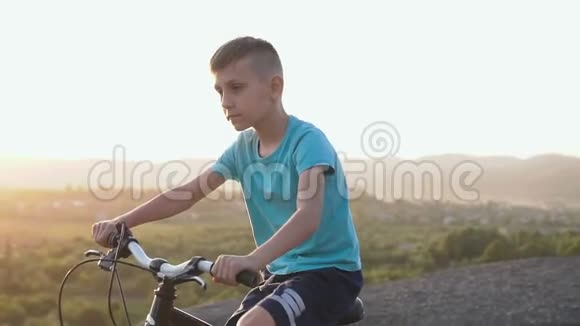 一个89岁的男孩穿着一件蓝色T恤骑着一辆自行车在山区背景是森林视频的预览图