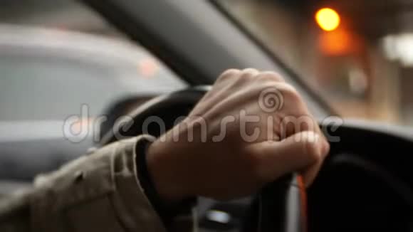 日落时分一个男人在城市里开车大城市的灯光背景模糊4k视频的预览图
