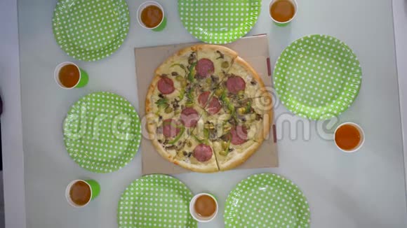 披萨派对朋友手拿切片披萨和空盘子桌上放啤酒的塑料杯视频的预览图