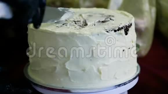 手工切巧克力蛋糕用刀子装饰白色奶油视频的预览图