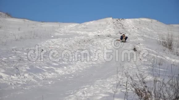 女孩在雪中滑下山坡女孩冬天在公园里玩慢动作视频的预览图