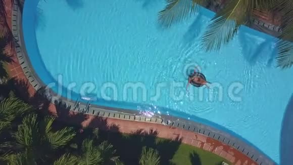 女人躺在后面沿着泳池航行视频的预览图