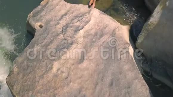 年轻女子穿着泳衣躺在大石头上的河水无人机景美丽的女人放松和日光浴视频的预览图