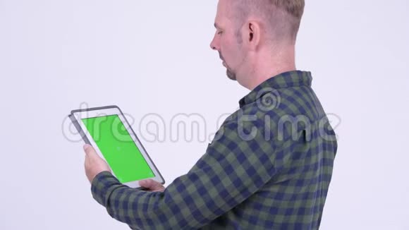 使用数码平板电脑的金发时髦男人的侧写视图视频的预览图