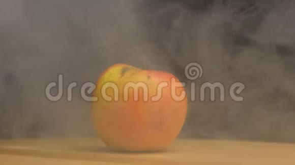 旋转苹果在黑色背景下在烟雾中吹出凉爽和新鲜的味道特写缓慢的mo视频的预览图