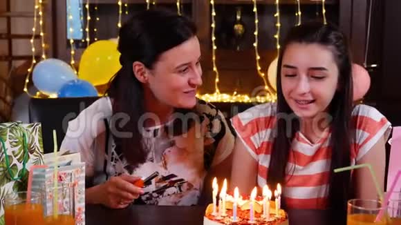 年轻女孩和妈妈带着生日蛋糕参加周年庆派对视频的预览图