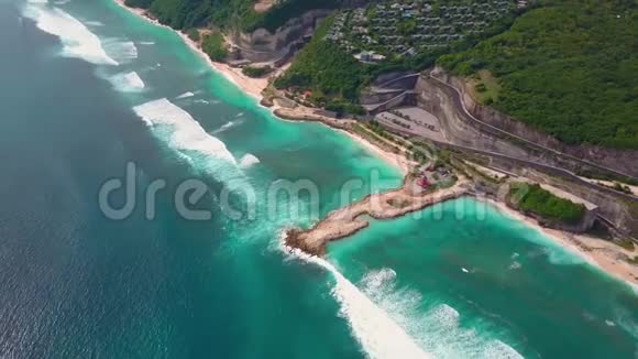 带绿松石海浪的部分岛屿的空中景观绿色悬崖上的别墅视频的预览图