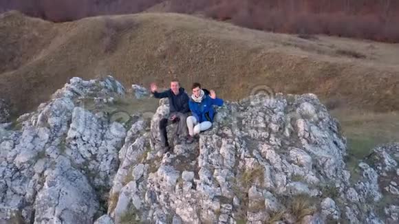 一对在山崖上放松的夫妇空中4k无人机电影视频的预览图