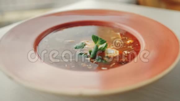 热罗沙汤加酸奶油和青菜放在盘子里视频的预览图