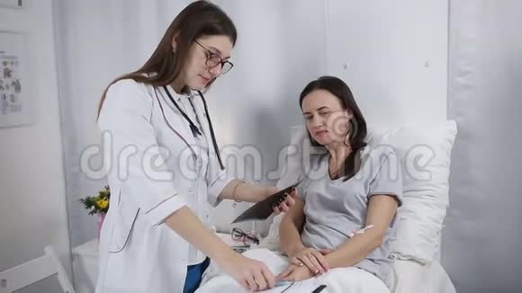 年轻的女医生和医院里的病人说话医生到医院病房探望病人视频的预览图