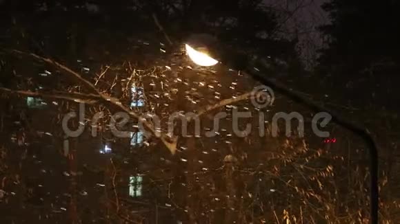 冬天的傍晚厚厚的雪落在一盏燃烧的灯笼的背景上视频的预览图