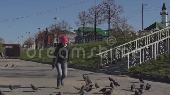 阳光明媚的一天年轻女子追逐鸽子视频的预览图
