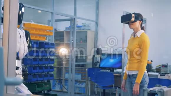一个女人检查机器人戴着VR眼镜虚拟现实概念视频的预览图