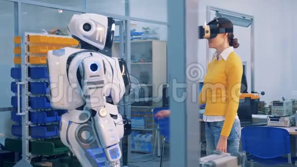一个戴着VR眼镜的女人检查机器人虚拟现实游戏理念视频的预览图