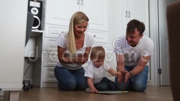 爸爸和妈妈坐在地板上为成功完成任务的孩子鼓掌视频的预览图