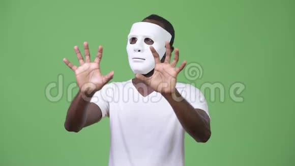 戴着白色面具想吓唬人的非洲年轻人视频的预览图