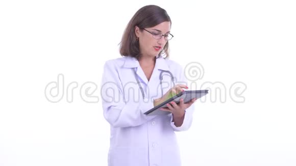 快乐美丽的女医生用数码平板电脑思考视频的预览图