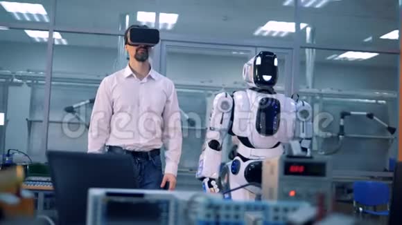 男工和机器人用手臂做动作虚拟现实游戏视频的预览图