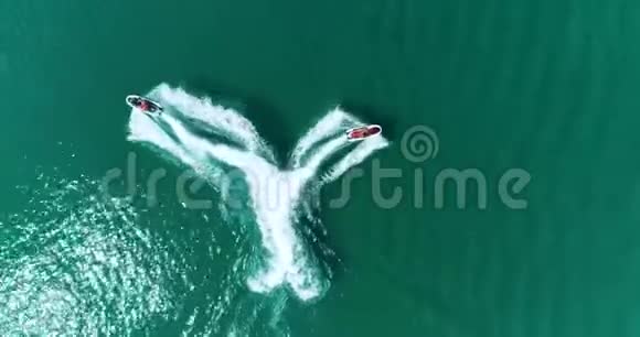 空中两辆水上自行车喷气式滑雪板在海上的水面上画出一个心形视频的预览图